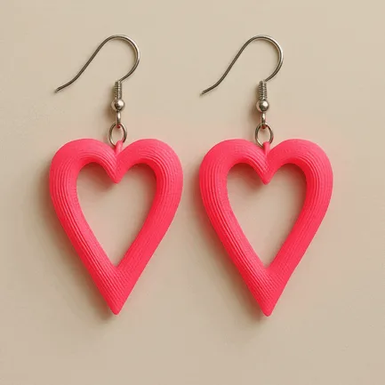 Pink heart dangle earrings with cut-out design and matte finish