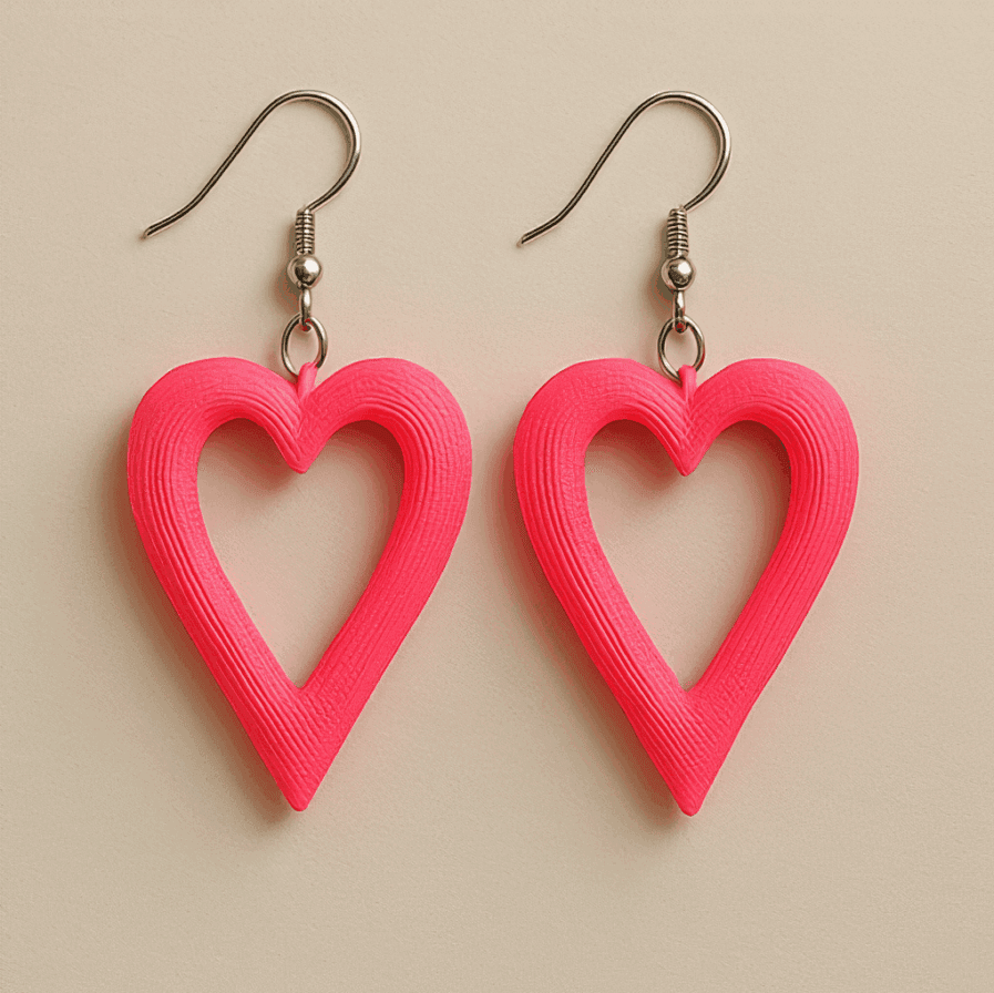 Pink heart dangle earrings with cut-out design and matte finish