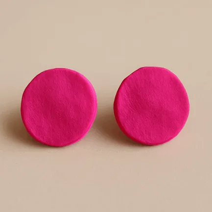 Pink round stud earrings with matte texture and bold circular shape