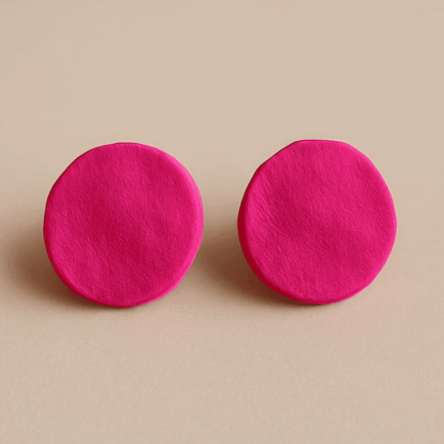Pink round stud earrings with matte texture and bold circular shape