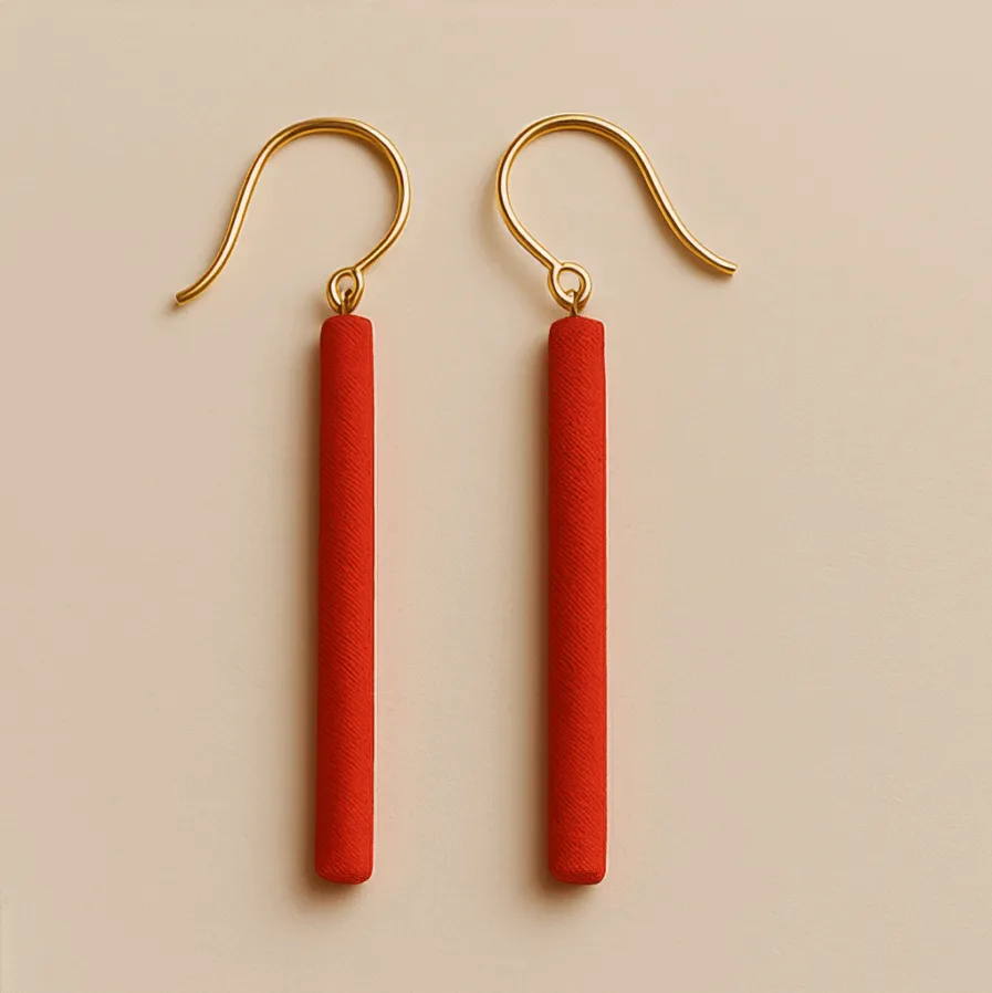 Long red dangle earrings with slim cylindrical shape and gold hooks